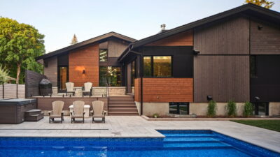 backyard of a renovated bungalow by RND Construction, showing contemporary siding and an inground pool
