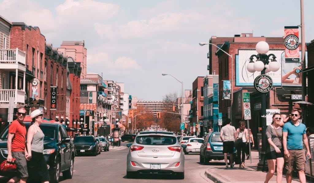 street scene in the ByWard Market in Ottawa showing shops, pedestrians and cars.