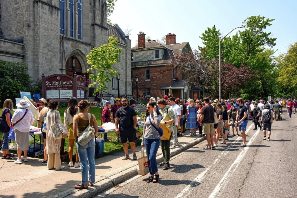 Dozens of visitors mill about outside St. Matthew’s Anglican Church in the Glebe during the Great Glebe Garage Sale