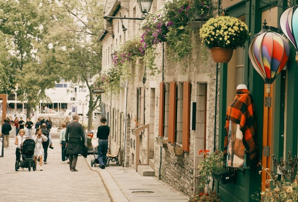 streetscape of stone buildings in Quebec City with pedestrians strolling