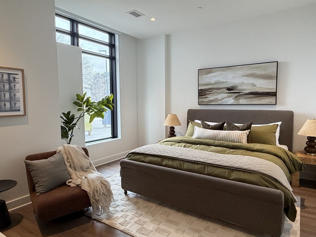 One of two guest suites, looking like a hotel room with large bed, night tables and lounge chair.