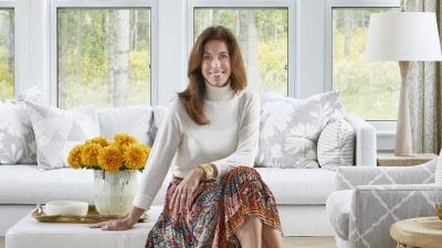 photo of designer Sarah Richardson sitting on an ottoman in a living room