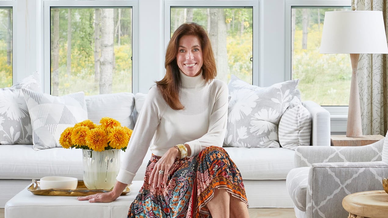 photo of designer Sarah Richardson sitting on an ottoman in a living room