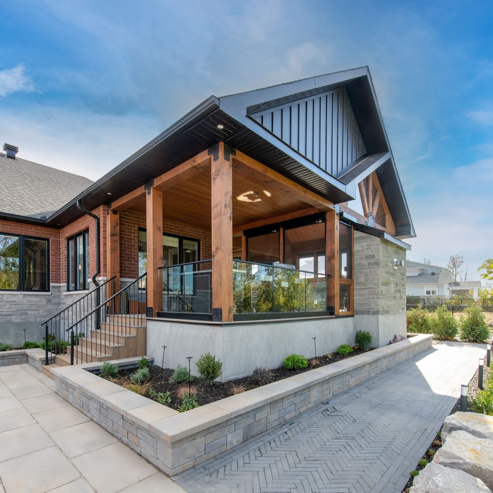 covered deck surrounded by interlock and a raised garden bedin a project by amsted design-build
