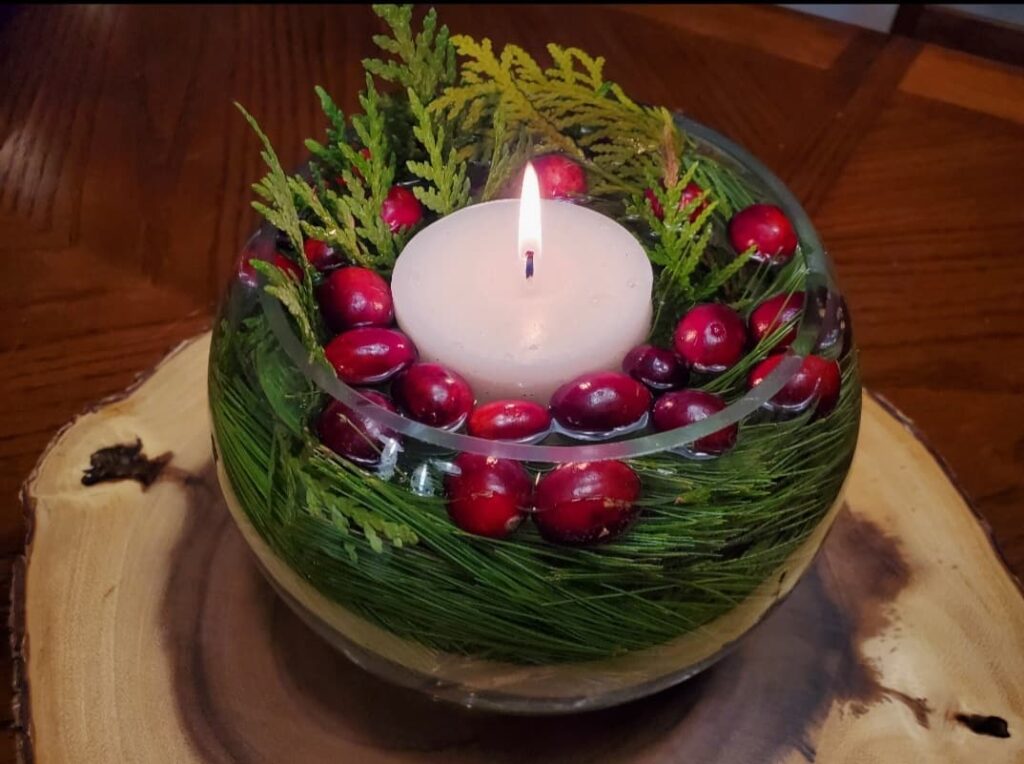 Christmas centrepiece with cranberries greenery and a candle