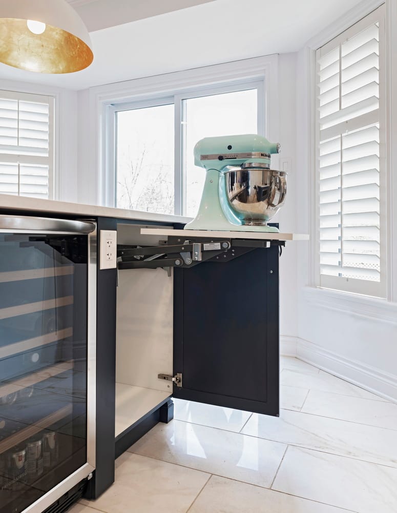 open kitchen cupboard showing a lift-out appliance stand