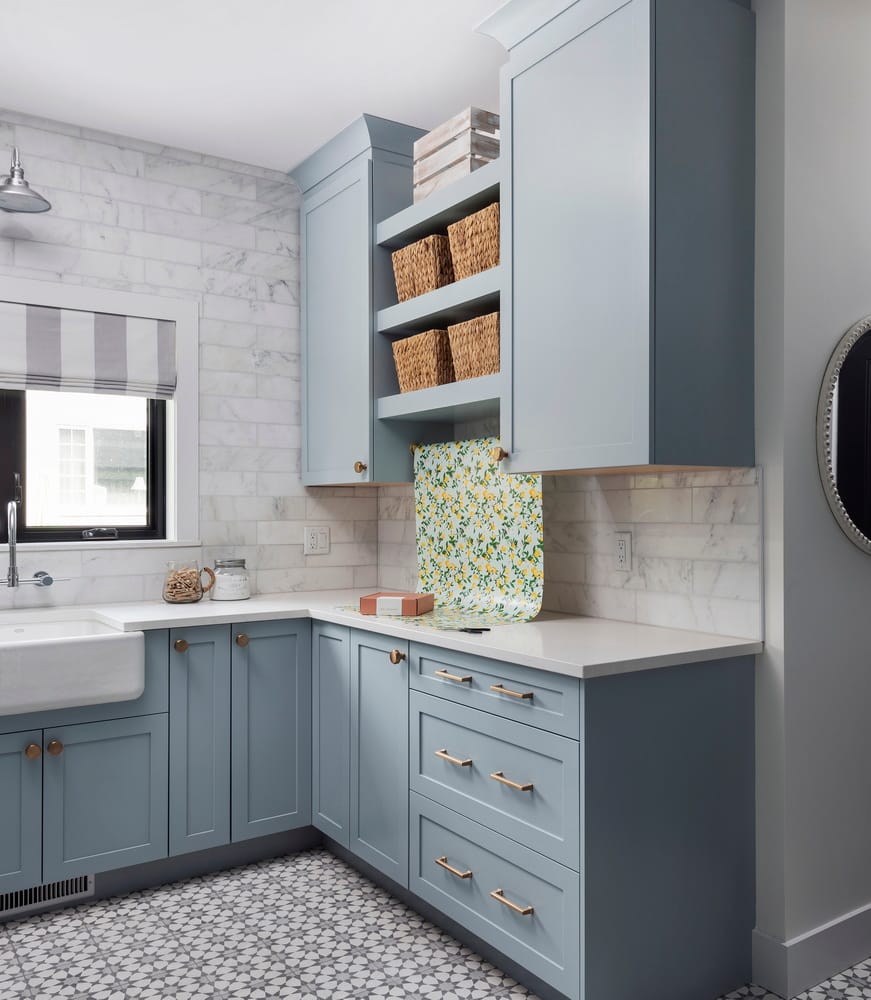 coastal inspired laundry room in pale blue with brick-style backsplash and an area for a gift-wrapping station
