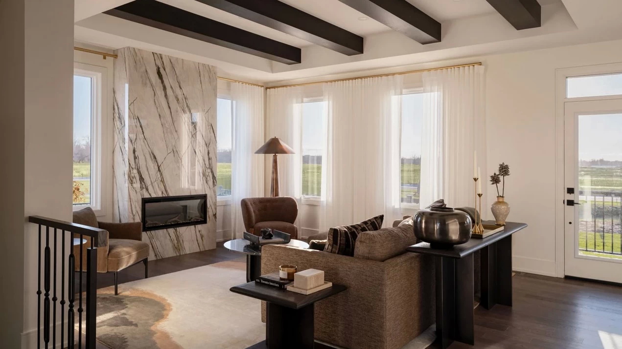 living room of Caivan’s Stonehaven Loft with ceiling beams and contemporary fireplace