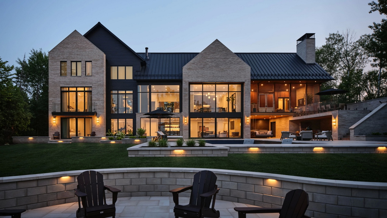 exterior and backyard of a waterfront custom home showing extensive glazing and dedicated outdoor spaces