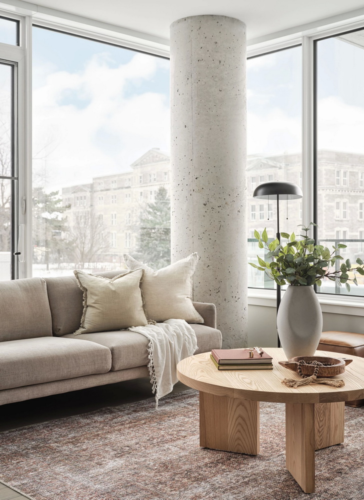 : living room of a unit at the Spencer condo building, showing exposed concrete column and floor-to-ceiling windows