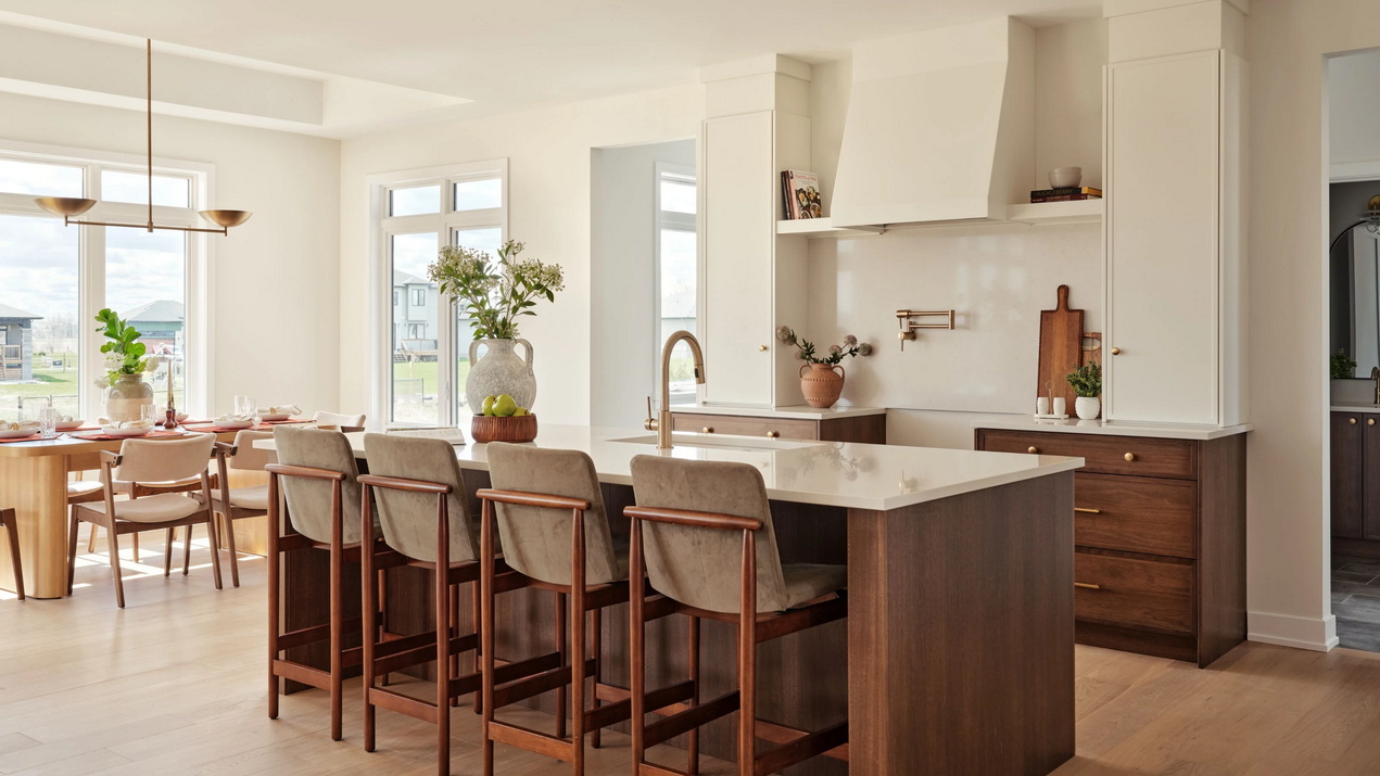 kitchen of the Casewood model by Mackie Homes with white upper cabinets and stained wood lowers and island