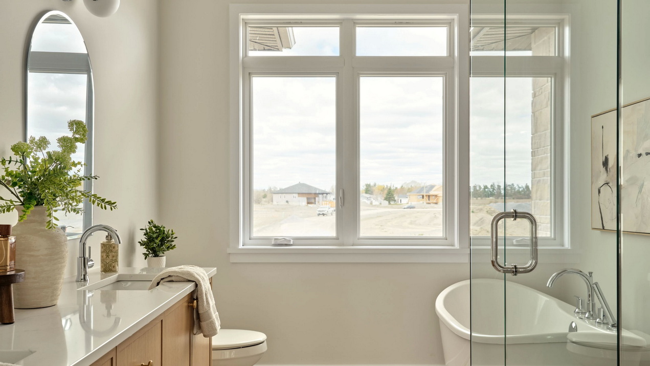 primary ensuite of the Casewood model showing the glassed-in shower and standalone soaker tub