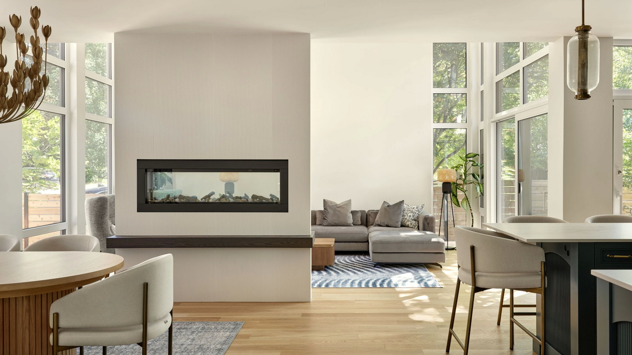 looking from the dining room of a custom home by RND Construction to the double-sided fireplace separating it from the great room