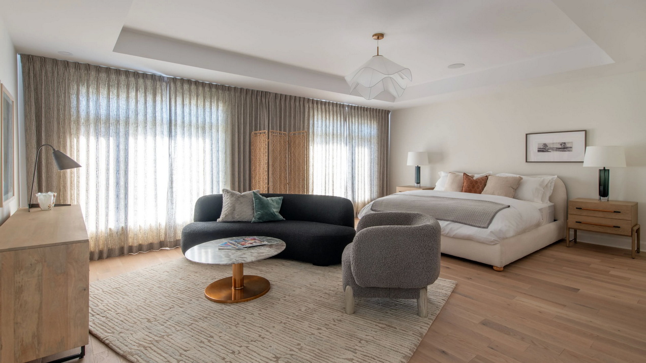 primary bedroom of the Esmonde model with generous sitting area and tray ceiling