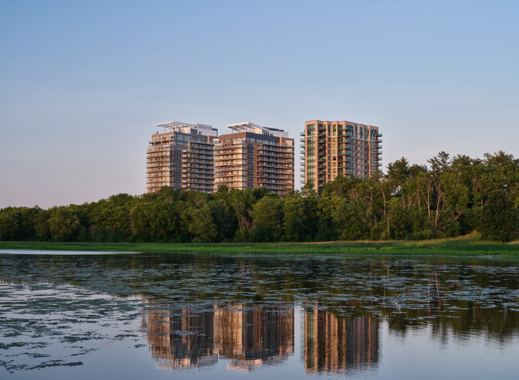 exterior of three of the towers at Petrie's Landing, with the Ottawa River in the foreground
