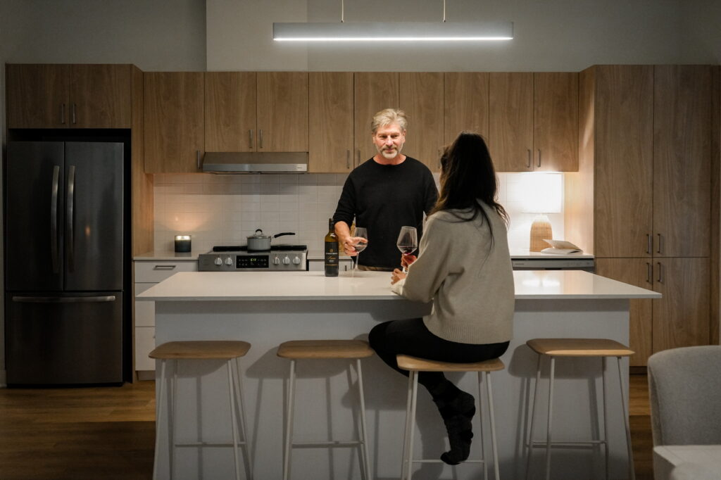 A couple at a kitchen island in one of the Petrie's Landing units