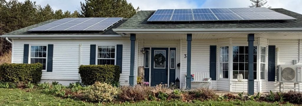 exterior of a white bungalow with solar panels and painted shutters