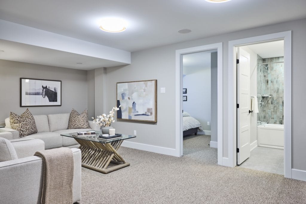 photo of the fully finished basement in the harmony townhome model by tamarack homes showing how a town can be multi-generational with a basement rec room bedroom and bathroom 