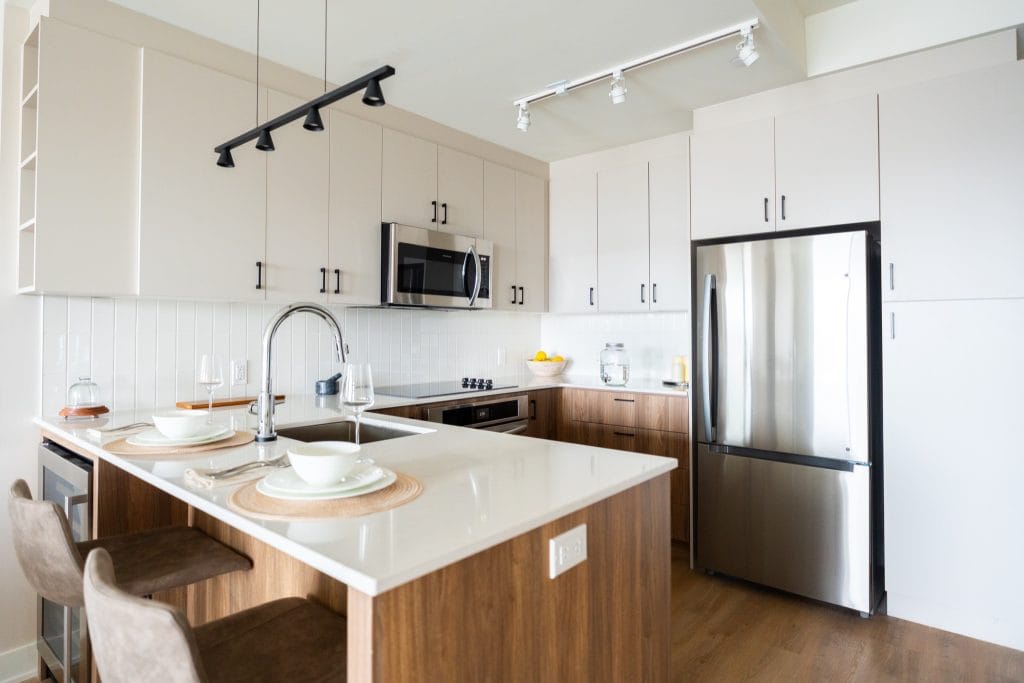 U-shaped kitchen with peninsula in a unit at The Clemow; wood lower cabinets and white uppers