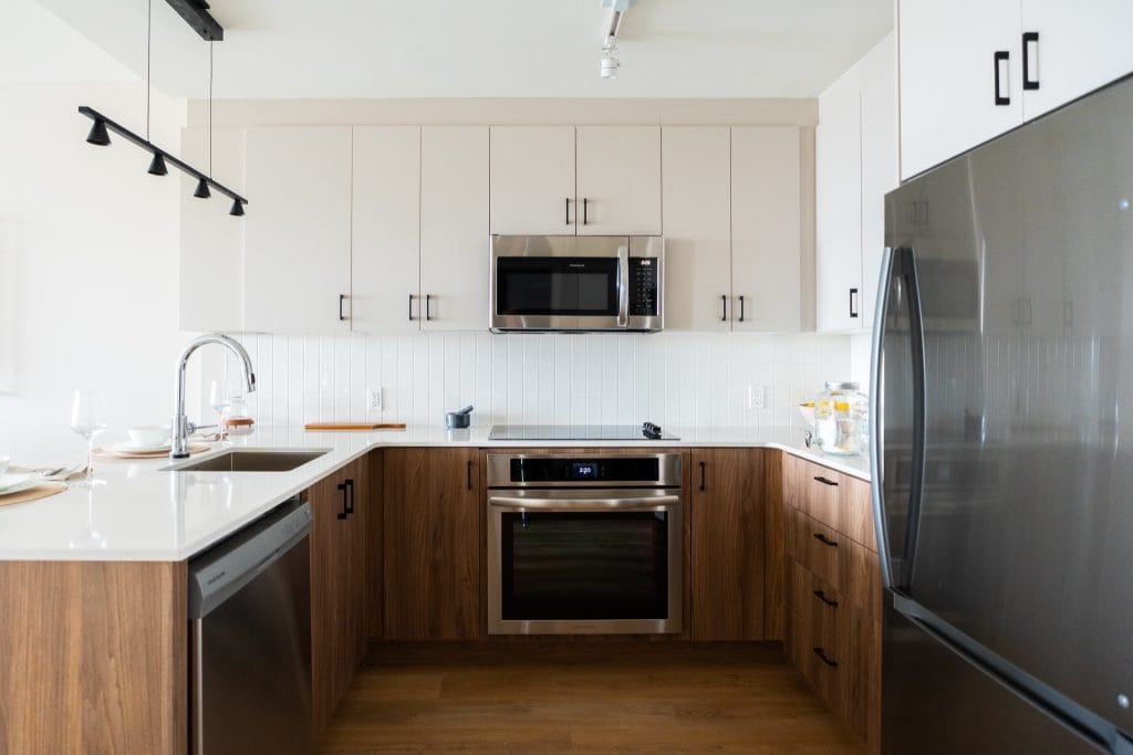 U-shaped kitchen in a unit at The Clemow, with wood lower cabinets and white uppers