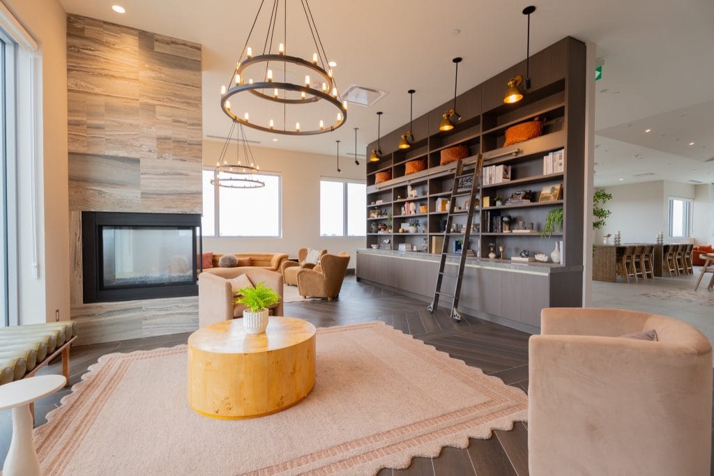 lounge area in the games room at The Clemow with fireplace and wall of built-in shelving