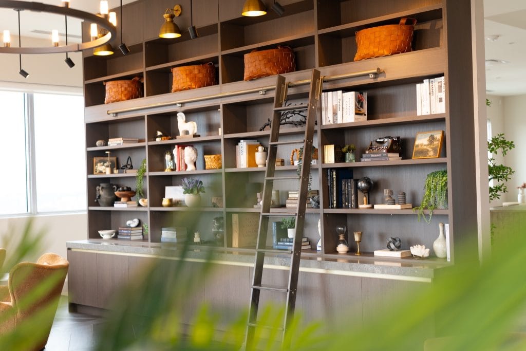 wall of built-in shelving with a sliding ladder used for storing games at The Clemow