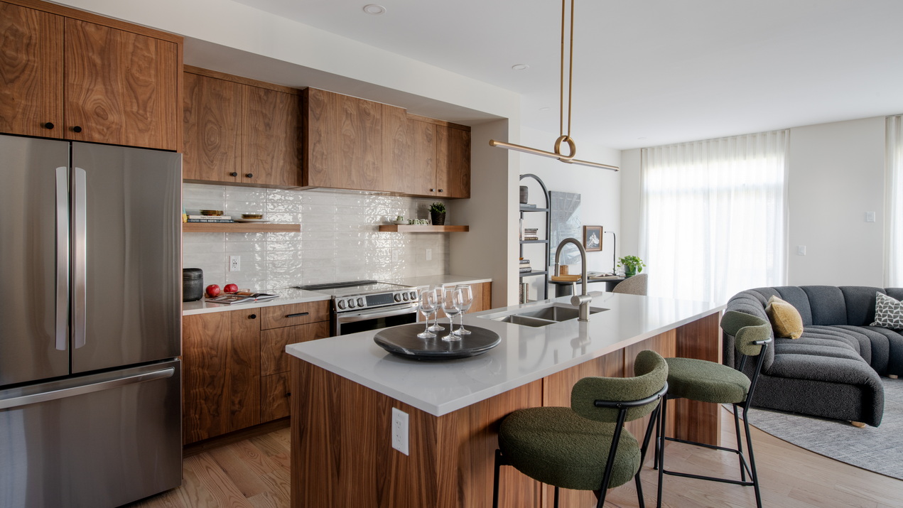 Open-concept kitchen and living room of the Driftwood townhome model by Uniform at Copperwood Estate