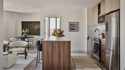 An open-concept kitchen, living room and dining room of an apartment at Centrepointe Union, with kitchen island.
