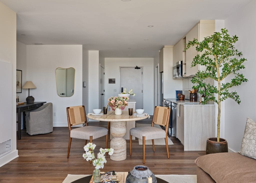 kitchen and dining area of an apartment at Centrepointe Union, with part of the living room showing in the foreground and a work space in the background