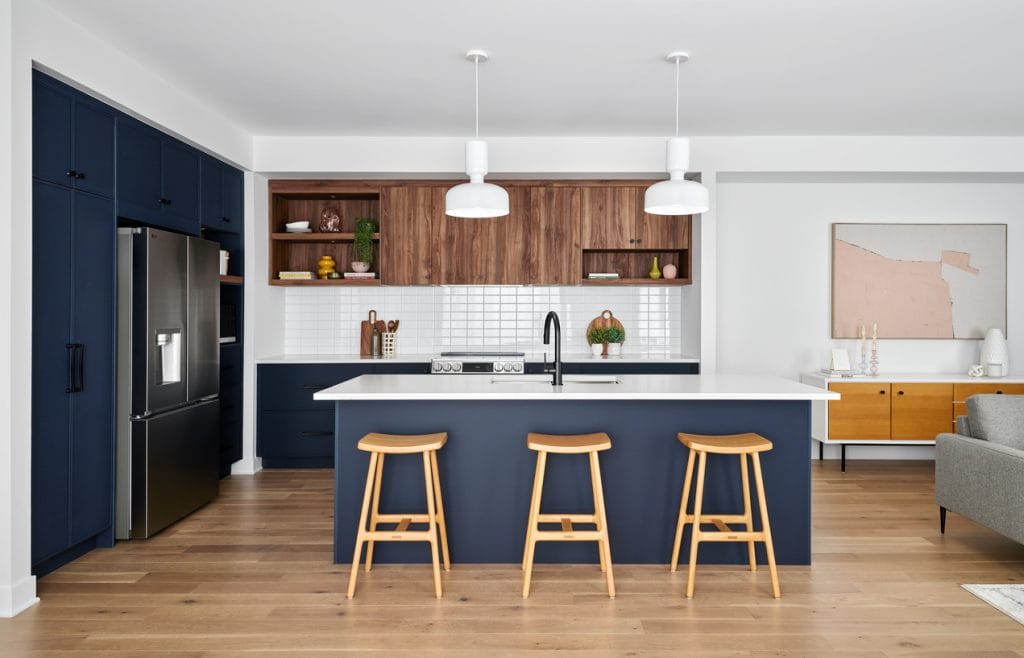 deep blue kitchen of the Santa Maria townhome model by Urbandale at Riverside South with an island and accent upper cabinets in rich wood